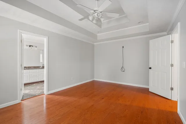 an empty room with closet and a ceiling fan
