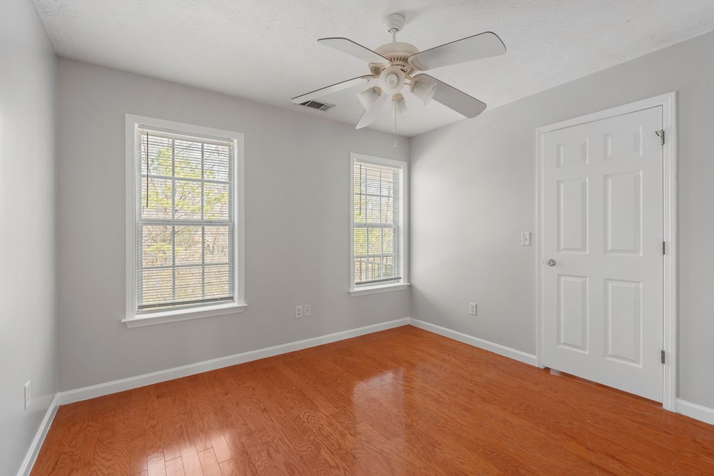 8016 Glen Valley Drive Midland, GA 31820 - Photo 21 of 31 an empty room with a chandelier fan and windows