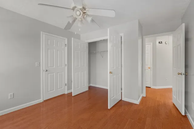 an empty room with closet and a chandelier fan