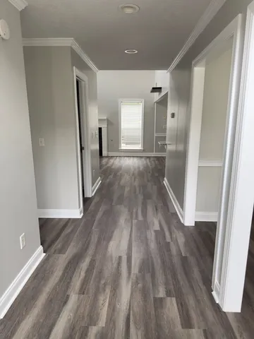 a view of a hallway with wooden floor and staircase