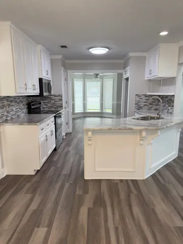 a kitchen with stainless steel appliances granite countertop a stove a sink and a refrigerator