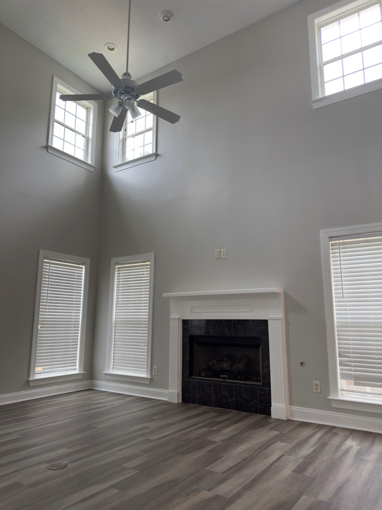 8016 Glen Valley Drive Midland, GA 31820 - Photo 7 of 31 an empty room with wooden floor fireplace and windows