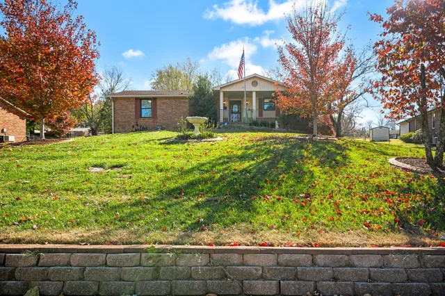 a front view of a house with a yard and potted plants