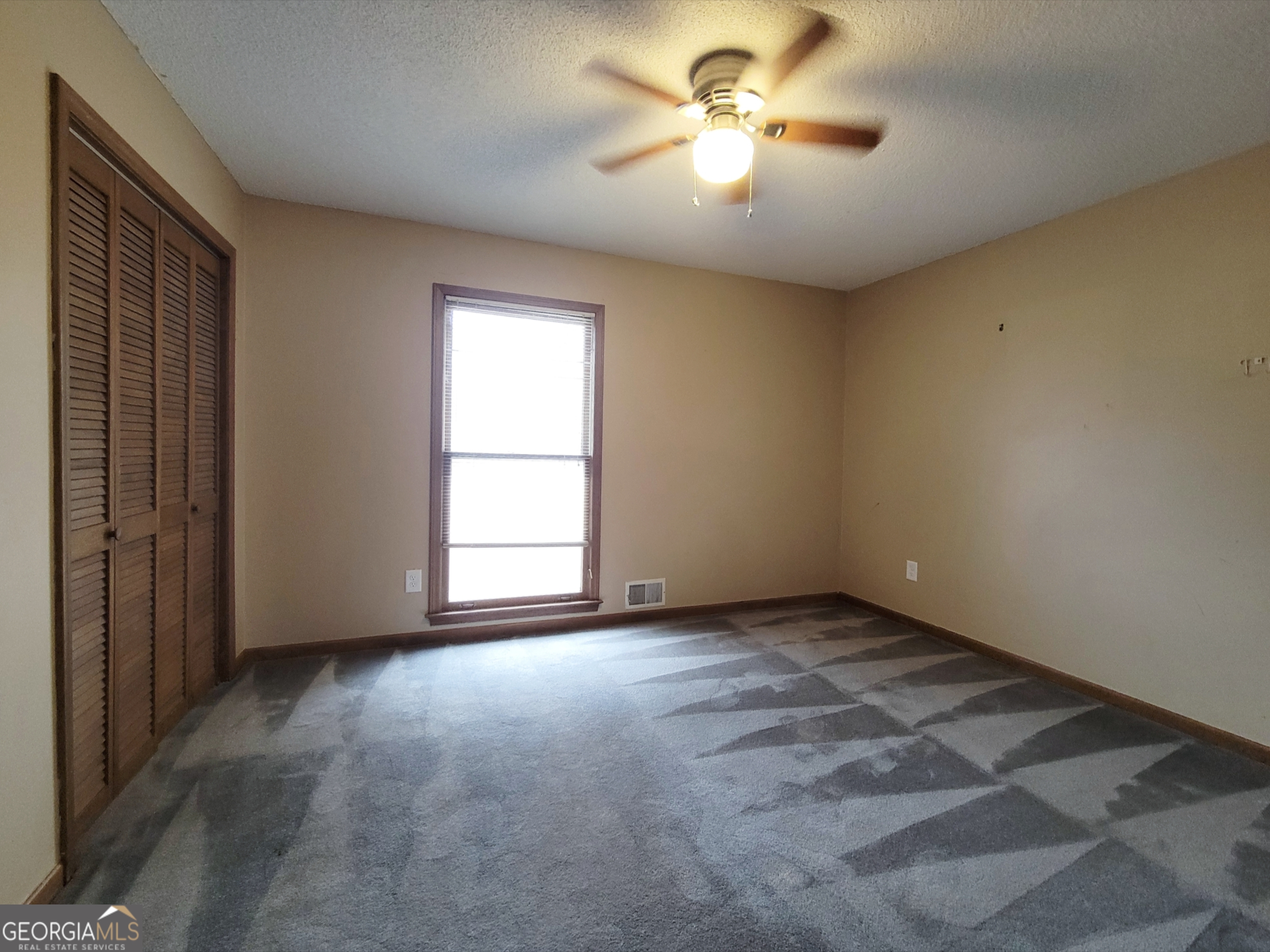 788 Harrison Mill Road Winder, GA 30680 - Photo 11 of 19 an empty room with chandelier fan and windows