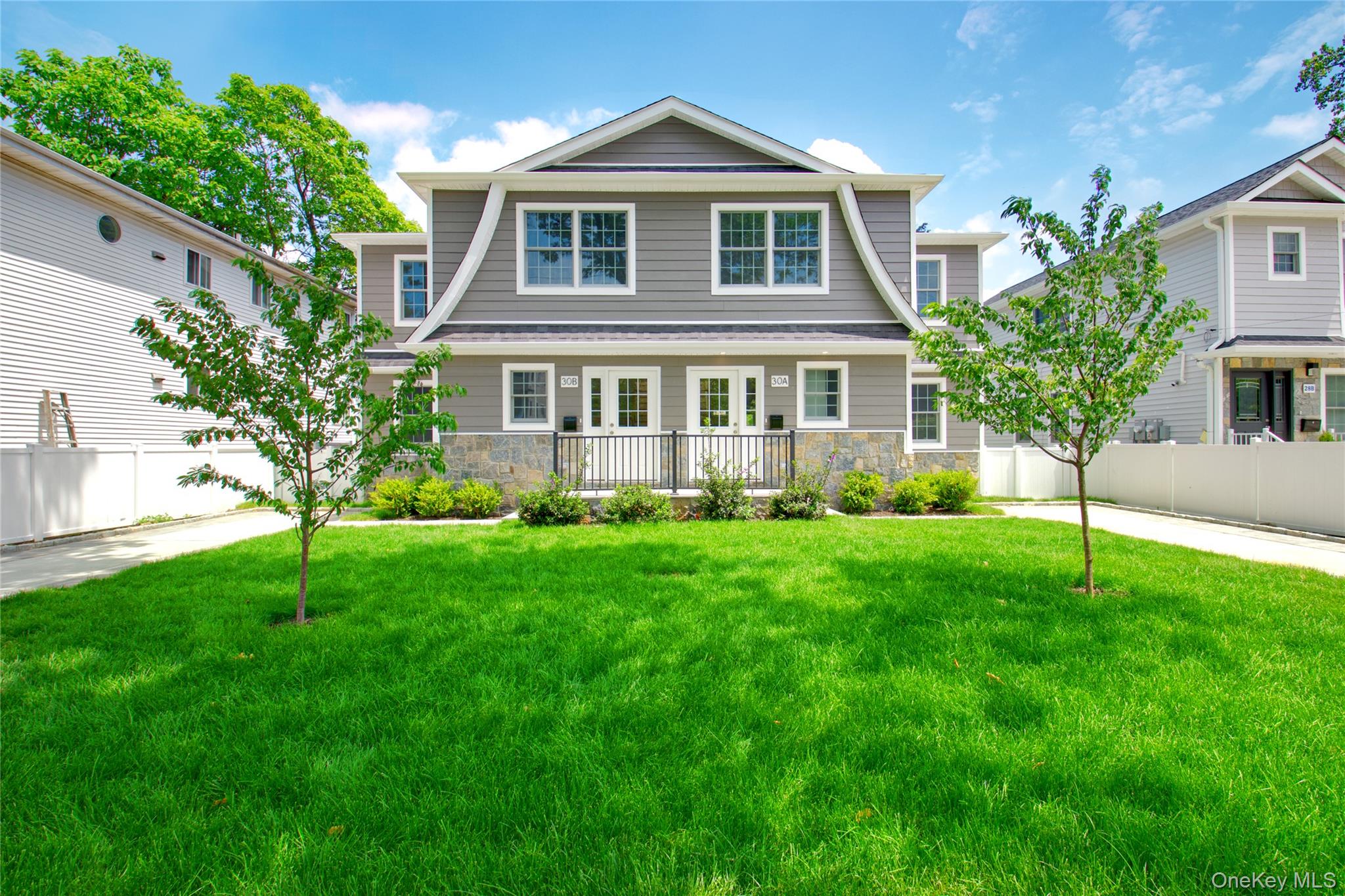 a front view of a house with a yard and garden