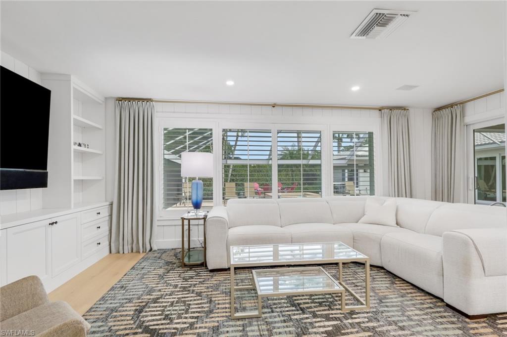 695 Regatta Road Naples, FL 34103 - Photo 11 of 43 Living room featuring built in shelves and light wood-type flooring