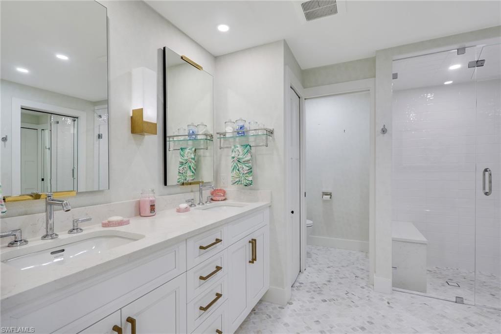 695 Regatta Road Naples, FL 34103 - Photo 15 of 43 Full bath featuring a shower stall, double vanity, recessed lighting, and light floors
