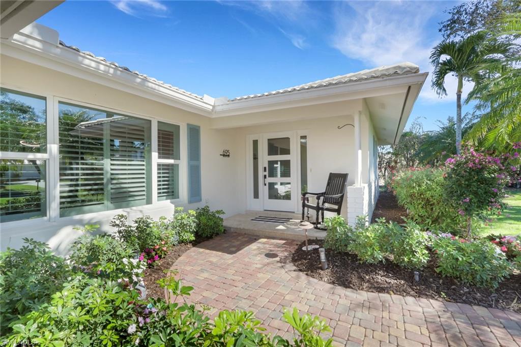 695 Regatta Road Naples, FL 34103 - Photo 2 of 43 Entrance to property featuring stucco siding and covered porch