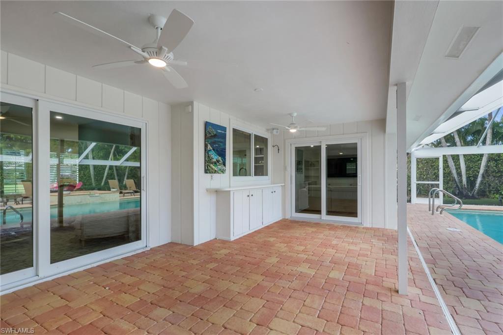 695 Regatta Road Naples, FL 34103 - Photo 30 of 43 View of patio / terrace with ceiling fan, an outdoor pool, a lanai, and a sunroom