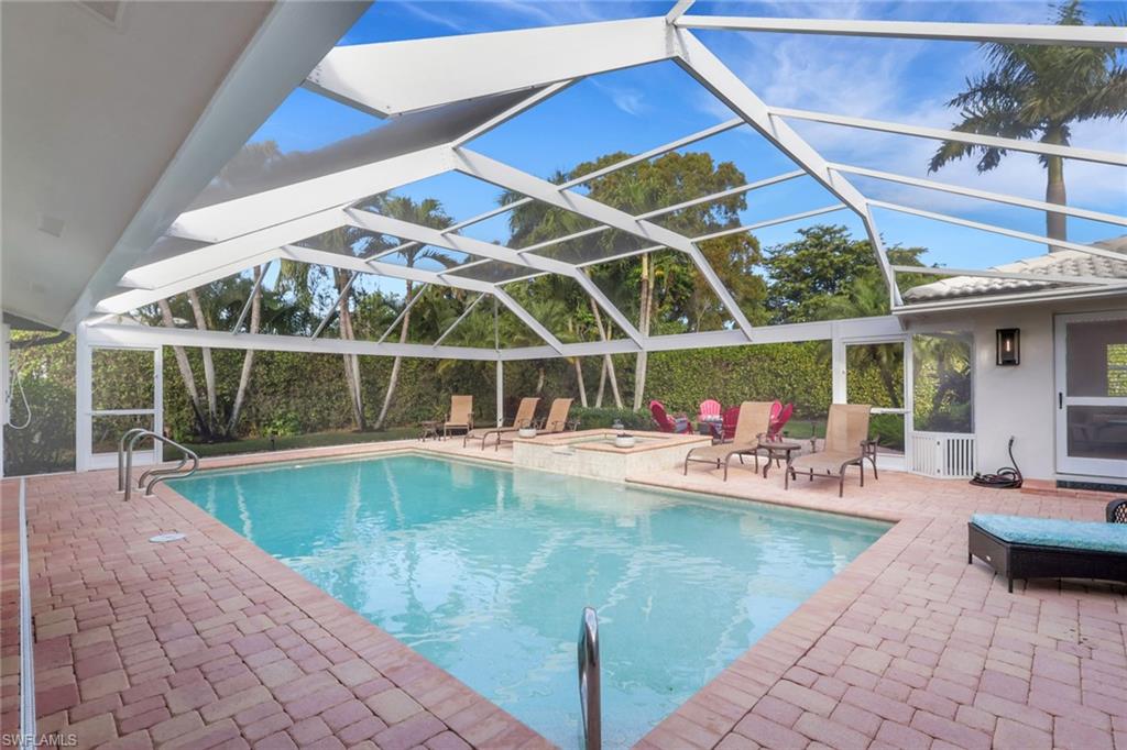 695 Regatta Road Naples, FL 34103 - Photo 34 of 43 View of pool featuring a lanai, a patio, a sunroom, and a pool with connected hot tub