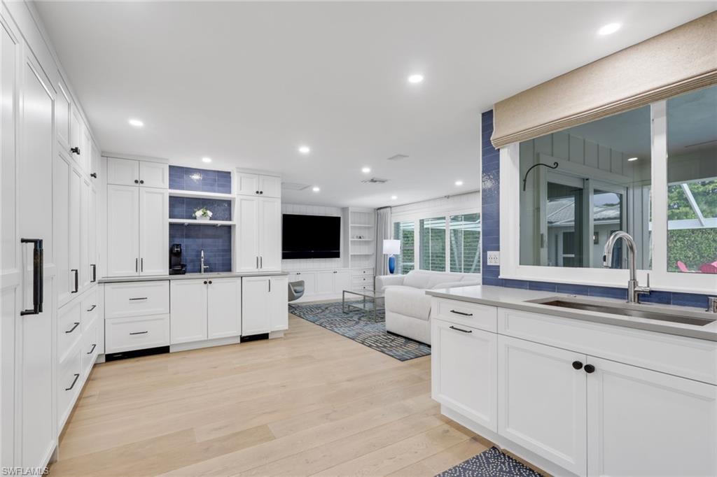 695 Regatta Road Naples, FL 34103 - Photo 43 of 43 Kitchen with open floor plan, white cabinets, light wood finished floors, and open shelves