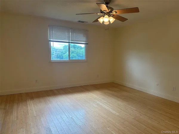 an empty room with fan and entrance
