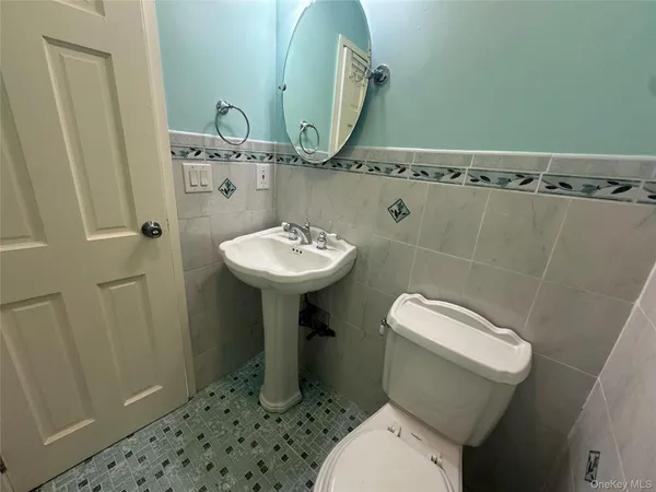 a bathroom with a sink toilet and mirror