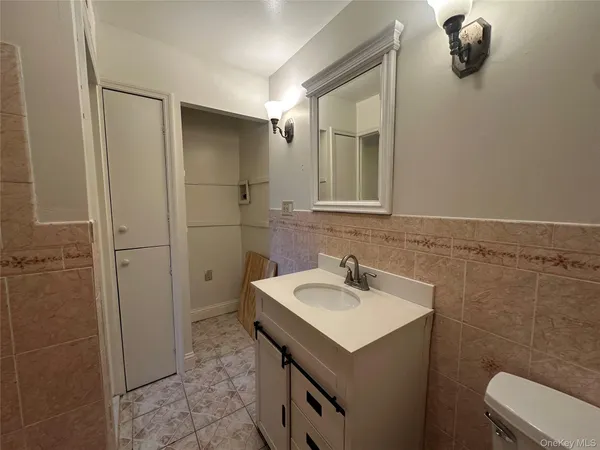 a view of an empty room with wooden floor and a ceiling fan