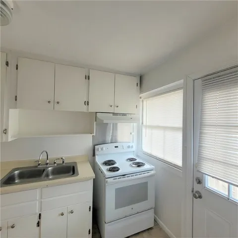 a kitchen with a sink stove and cabinets