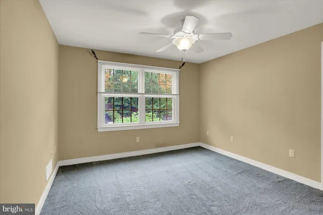 an empty room with closet and a chandelier fan