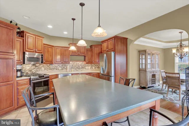 a kitchen with granite countertop stainless steel appliances wooden cabinets and a sink