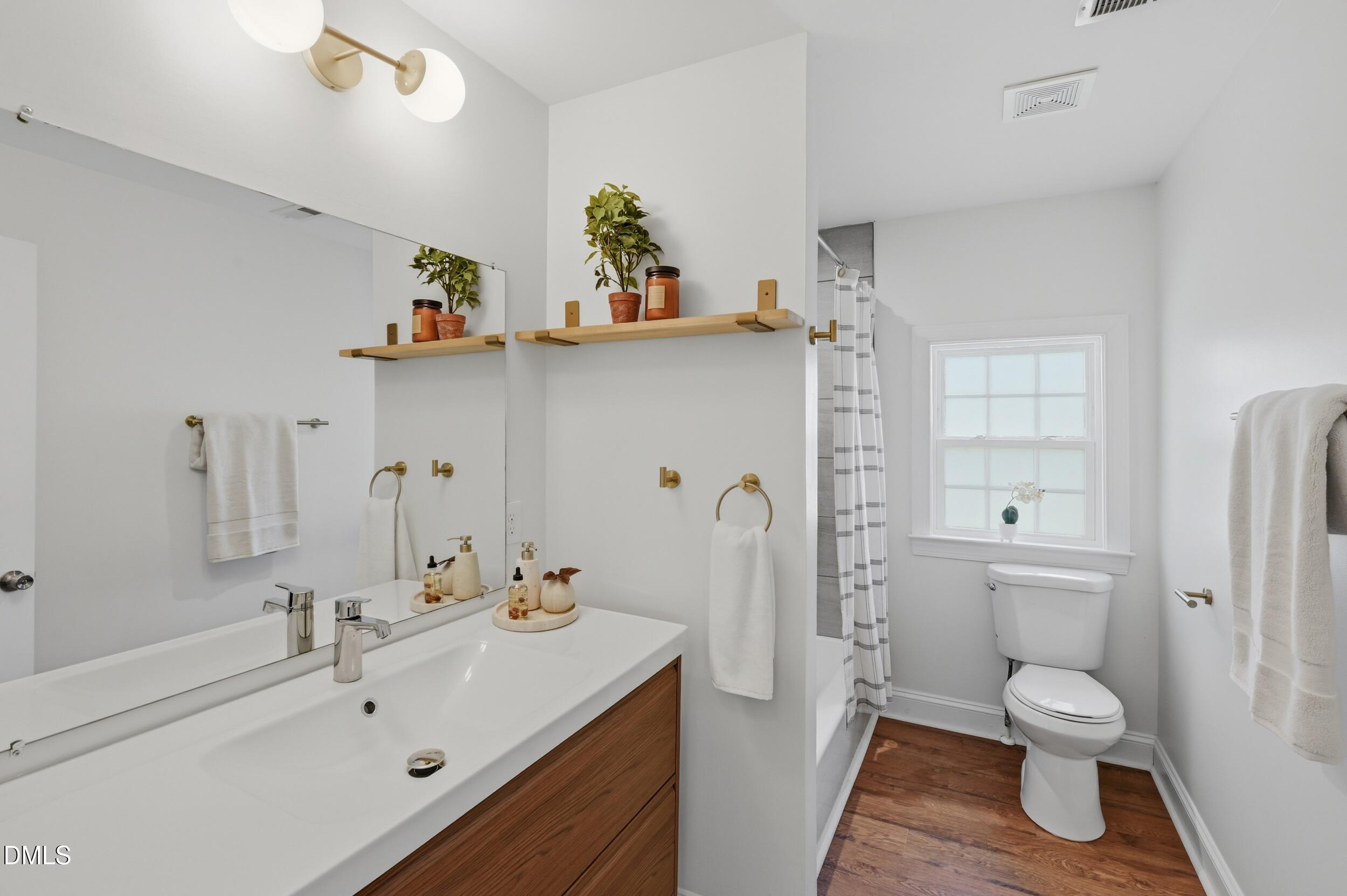 2301 Milburnie Road Raleigh, NC 27610 - Photo 10 of 23 a bathroom with a sink a toilet and shower curtain