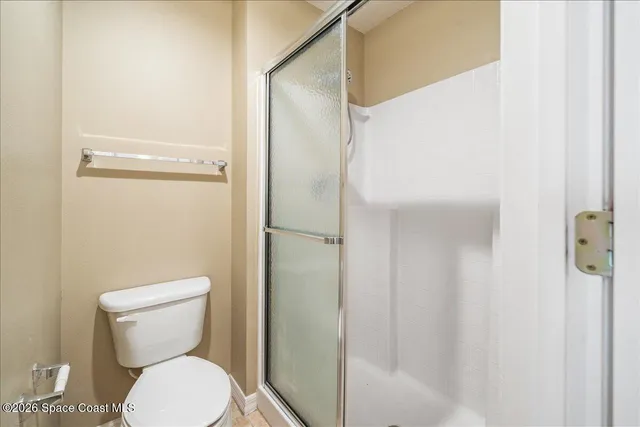 a white toilet sitting next to a shower