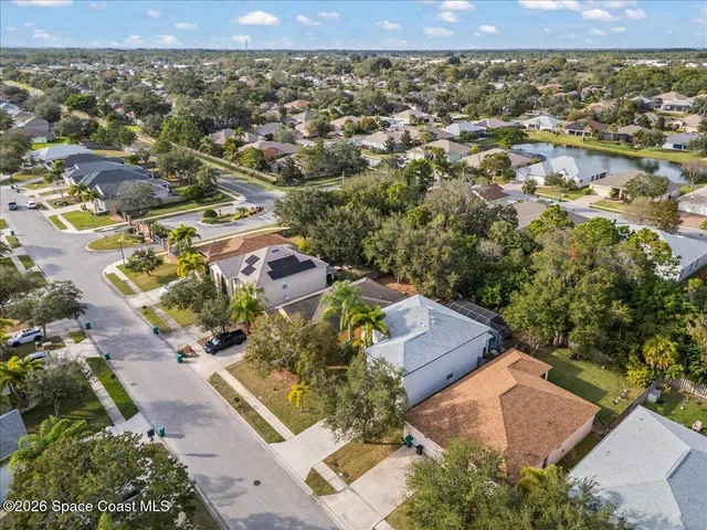 an aerial view of a house with a yard and lake view in back