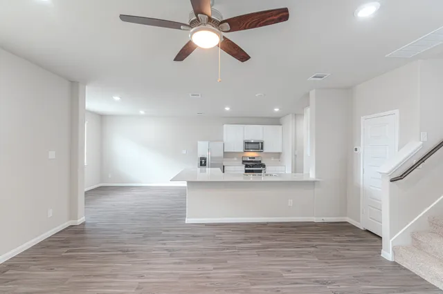 a view of kitchen with kitchen island wooden floor and ceiling fan