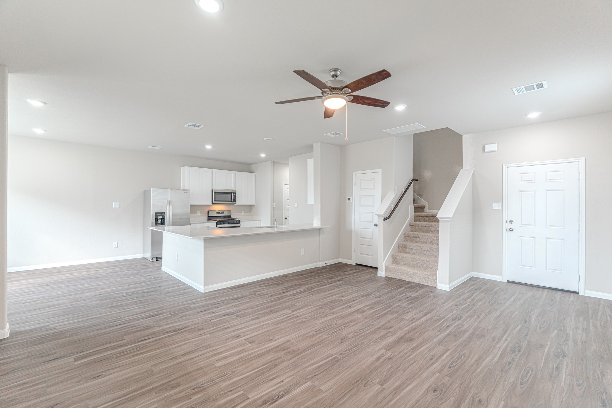 9219 Grace Rdg Drive Willis, TX 77318 - Photo 12 of 44 a view of a kitchen with wooden floor and a ceiling fan