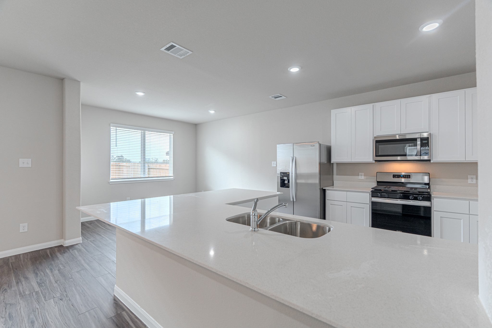 9219 Grace Rdg Drive Willis, TX 77318 - Photo 15 of 44 a kitchen with stainless steel appliances a sink a stove a microwave a sink a refrigerator with white cabinets and wooden floor