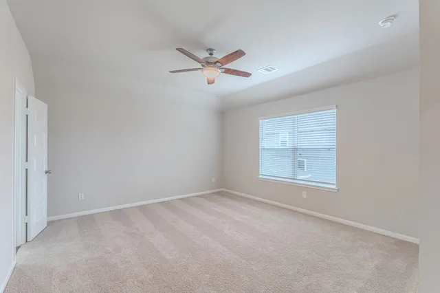 an empty room with windows and fan