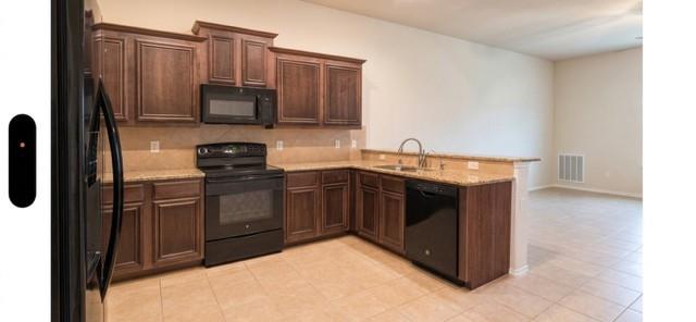 415 Harding Lane Lavon, TX 75166 - Photo 6 of 13 Kitchen featuring wood-finish cabinetry, granite-style countertops, and beige tile flooring