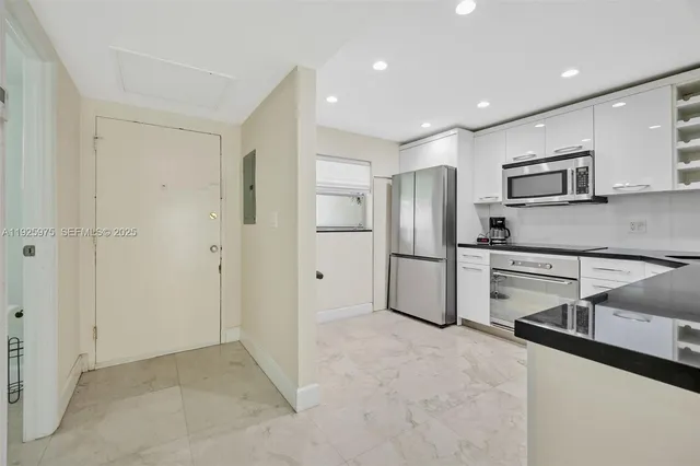 a kitchen with stainless steel appliances granite countertop a refrigerator and a sink