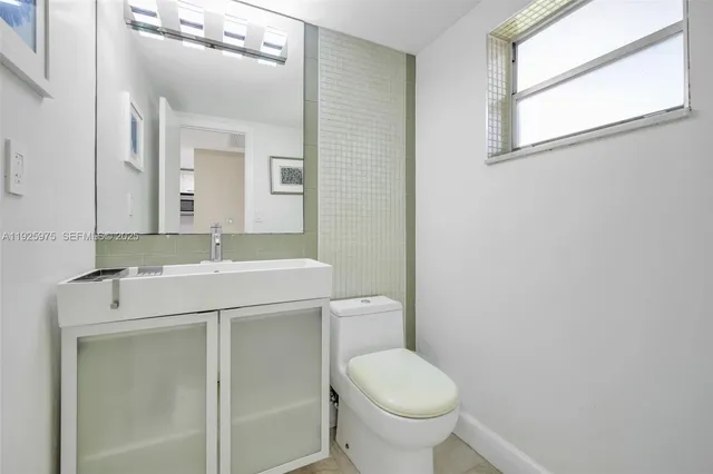 a bathroom with a sink toilet and mirror