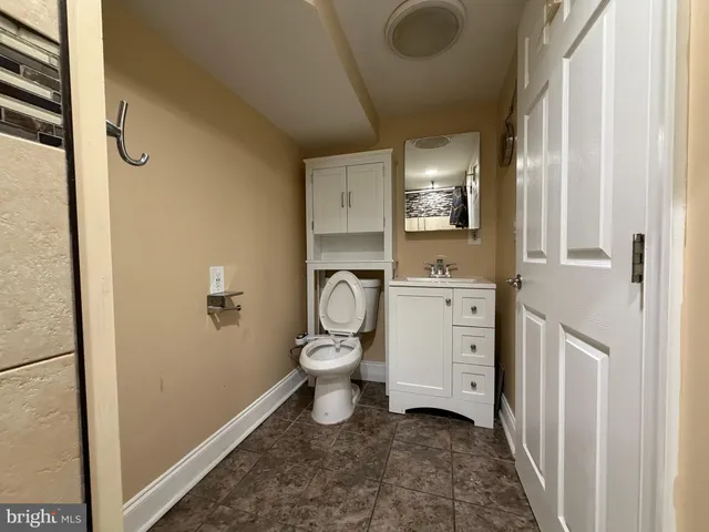 a bathroom with a toilet sink a mirror and shower
