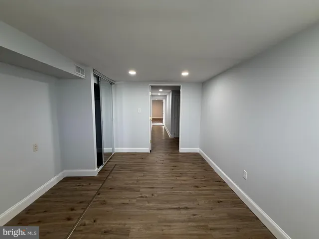 a view of an empty room with wooden floor