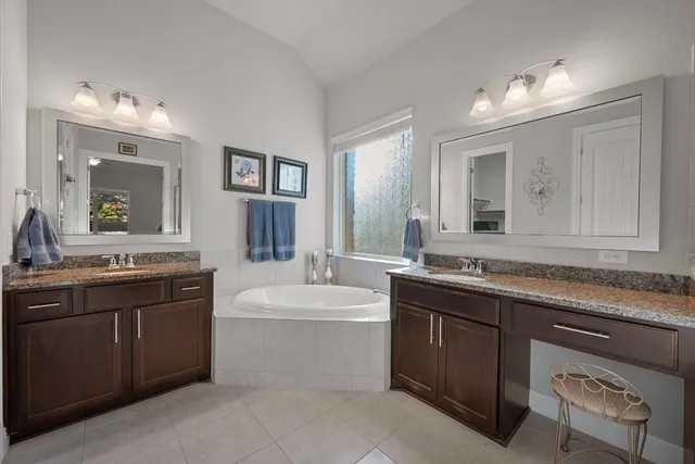 a bathroom with a sink double vanity granite and a mirror