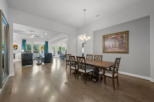 a dining room with furniture wooden floor a rug and a painting