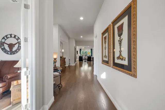 a view of a hallway with wooden floor and a livingroom