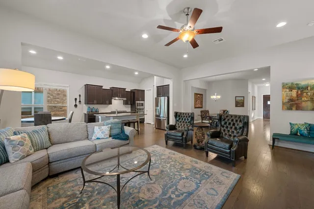 a living room with furniture kitchen view and a large window