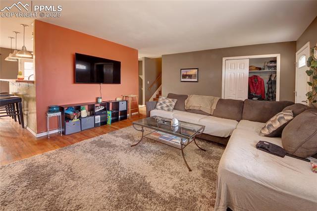 Living area with wood finished floors and stairway