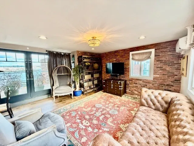 a living room with furniture a flat screen tv and a large window