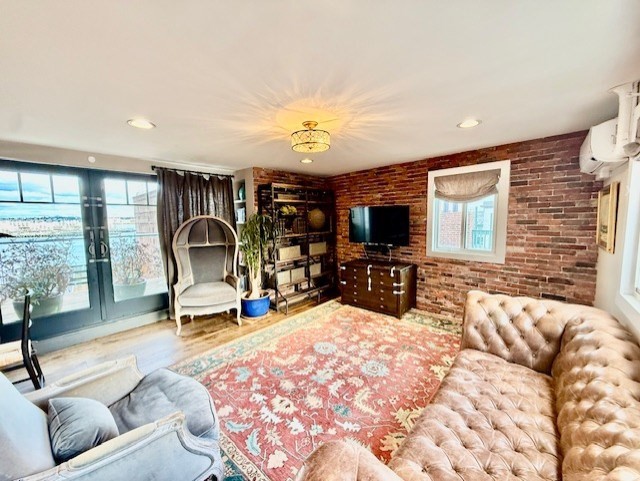 480 Commercial Street, Unit 5A Boston, MA 02109 - Photo 6 of 41 a living room with furniture a flat screen tv and a large window