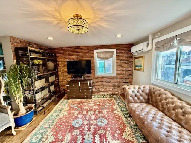 a living room with furniture a flat screen tv and a floor to ceiling window