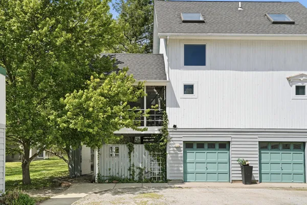 a front view of a house with a tree