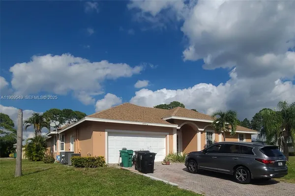 a view of a car parked in front of house and a yard