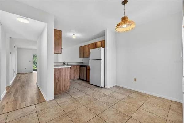 a view of a kitchen with refrigerator and wooden floor