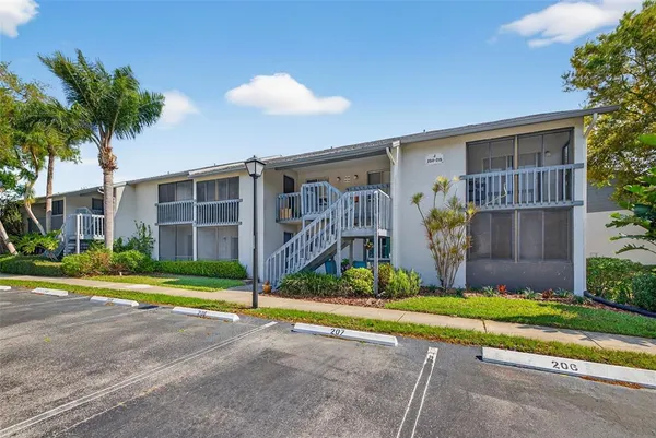 a front view of a house with a yard and potted plants