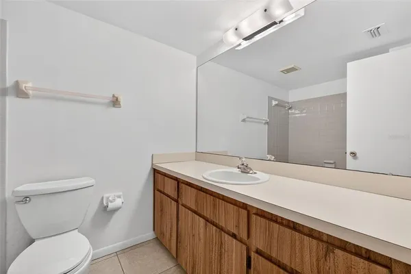 a bathroom with a granite countertop sink a large mirror and toilet
