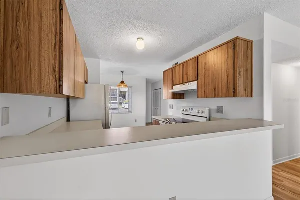 a kitchen with stainless steel appliances granite countertop a sink refrigerator and cabinets