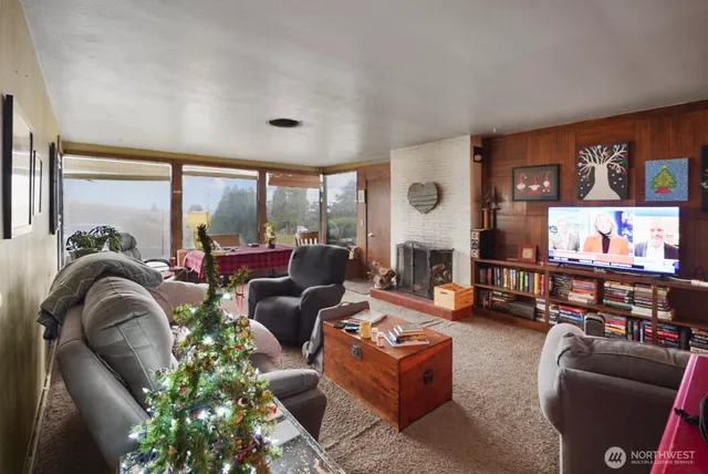 a living room with fireplace furniture and a large window
