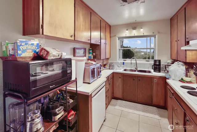 a kitchen with granite countertop lots of clutter and stainless steel appliances