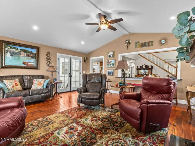 a living room with furniture a flat screen tv and a floor to ceiling window